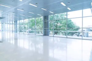 blurred-abstract-background-interior-view-looking-out-toward-empty-office-lobby-entrance-doors-glass-curtain-wall-with-frame